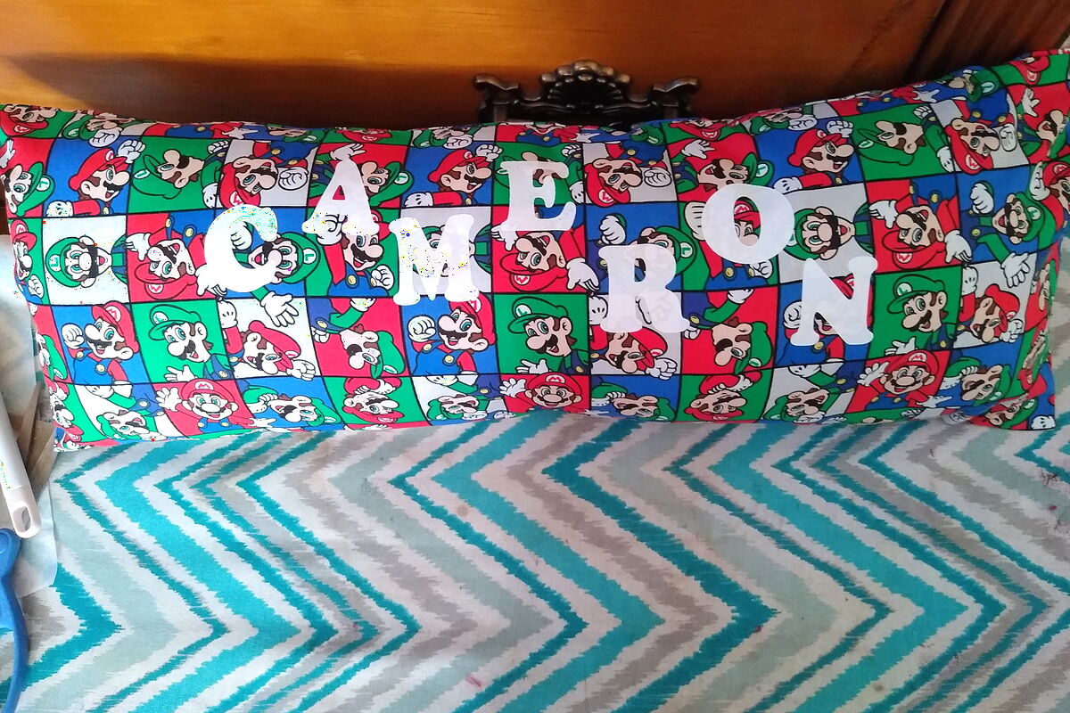 A custom body pillow with a name stitched across the front